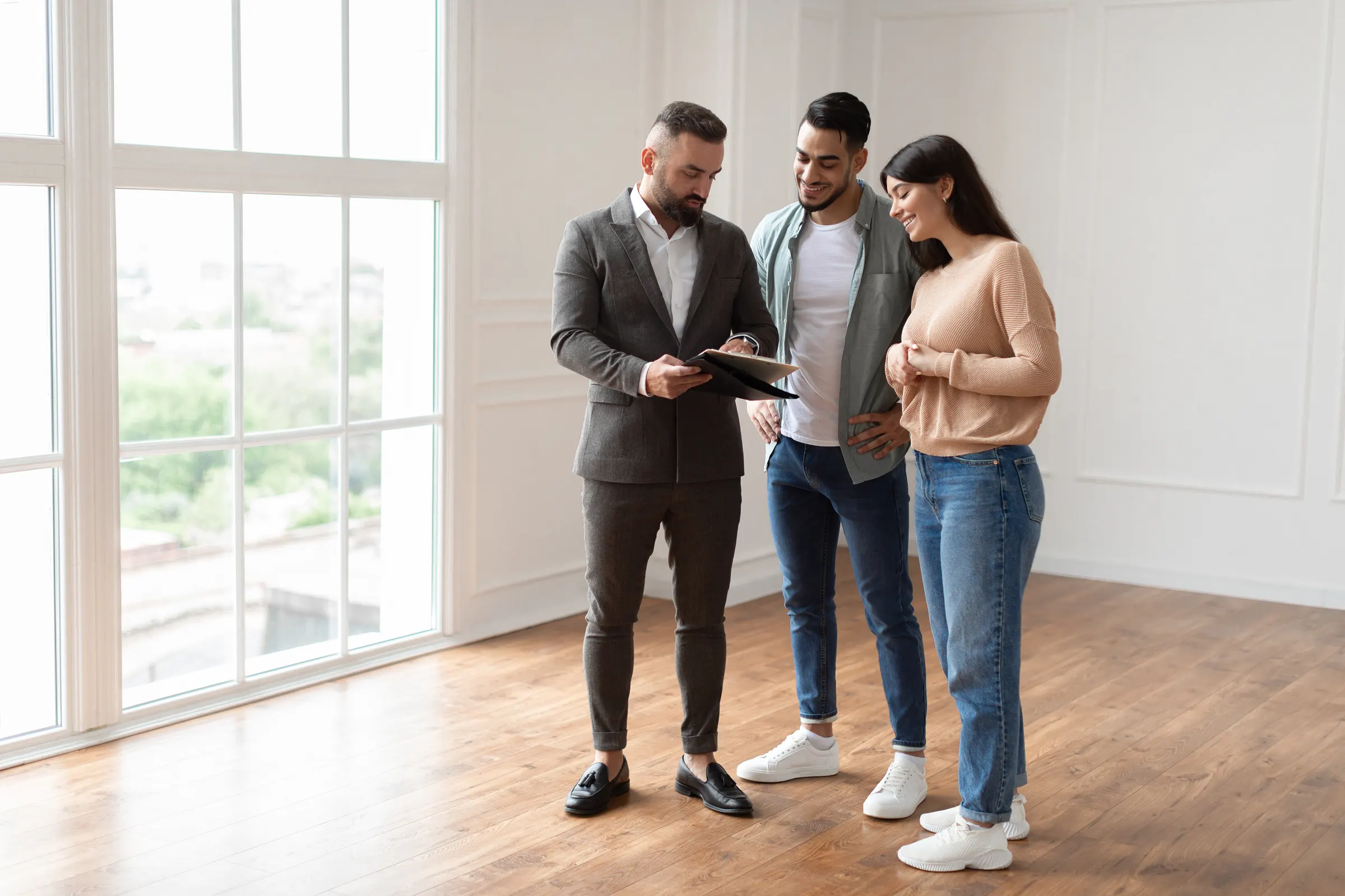 A sales advisor walking a young couple through a home